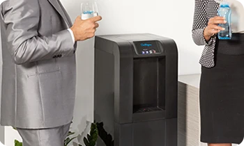 Office workers discussing with water, next to a Culligan water cooler